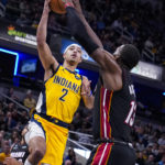 
              Indiana Pacers guard Andrew Nembhard (2) shoots over Miami Heat center Bam Adebayo (13) during the second half of an NBA basketball game in Indianapolis, Friday, Nov. 4, 2022. The Pacers defeated the Heat 101-99. (AP Photo/Michael Conroy)
            