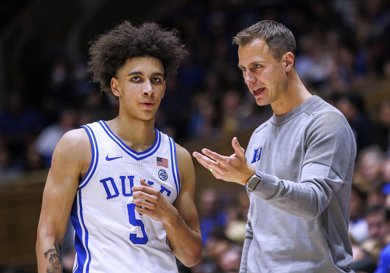 Duke coach Jon Scheyer speaks with Tyrese Proctor during the second half of the team's NCAA college...