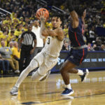 
              Michigan guard Jaelin Llewellyn, left, drives to the basket as he is guarded by Jackson State guard Chase Adams in the second half of an NCAA college basketball game, Wednesday, Nov. 23, 2022, in Ann Arbor, Mich. (AP Photo/Jose Juarez)
            