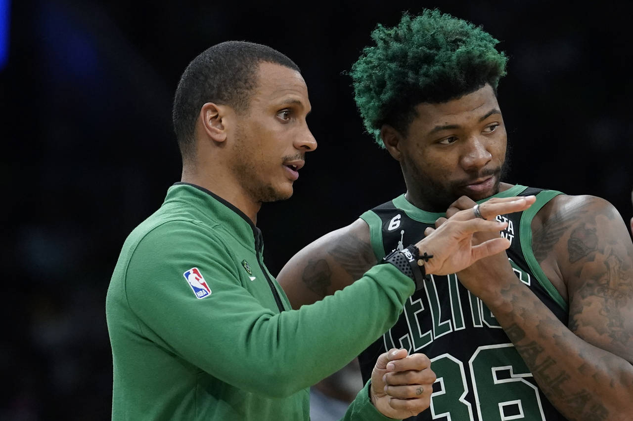 Boston Celtics interim head coach Joe Mazzulla, left, speaks with guard Marcus Smart, right, in the...