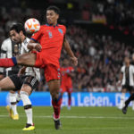 
              FILE - Germany's Ilkay Gundogan, left, challenges for the ball with England's Jude Bellingham during the UEFA Nations League soccer match between England and Germany at the Wembley Stadium in London, England, Monday, Sept. 26, 2022. (AP Photo/Alastair Grant, File)
            