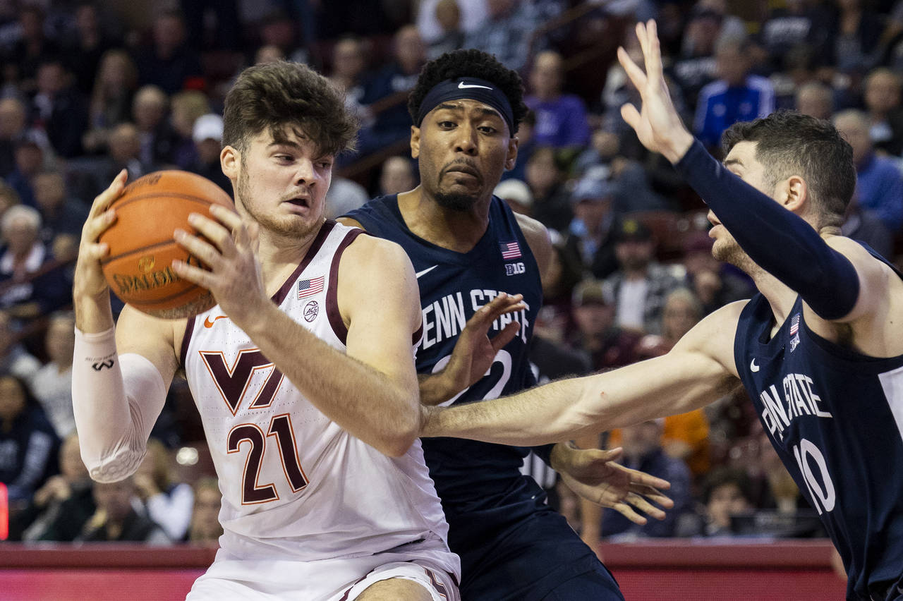 Virginia Tech's Grant Basile (21) goes up for a shot as Penn State's Andrew Funk (10) defends in th...
