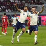 
              England's Jude Bellingham, centre, celebrates with England's Mason Mount after scoring his side's opening goal during the World Cup group B soccer match between England and Iran at the Khalifa International Stadium in Doha, Qatar, Monday, Nov. 21, 2022. (AP Photo/Alessandra Tarantino)
            