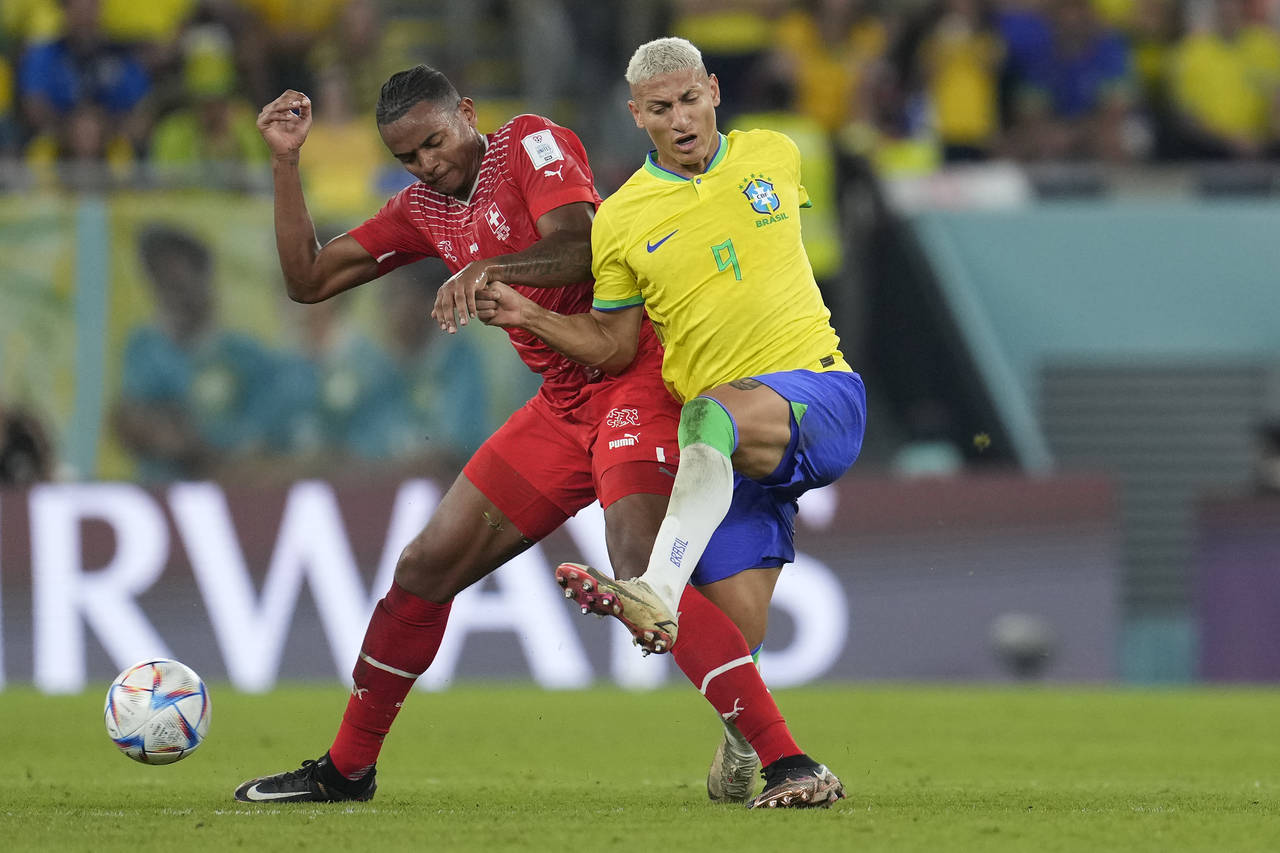 Switzerland's Ricardo Rodriguez, left, and Brazil's Richarlison challenge for the ball during the W...