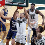 
              Michigan State's Pierre Brooks (1) grabs a rebound against Northern Arizona's Carson Towt (33) and Nik Mains, right, during the first half of an NCAA college basketball game Monday, Nov. 7, 2022, in East Lansing, Mich. (AP Photo/Al Goldis)
            