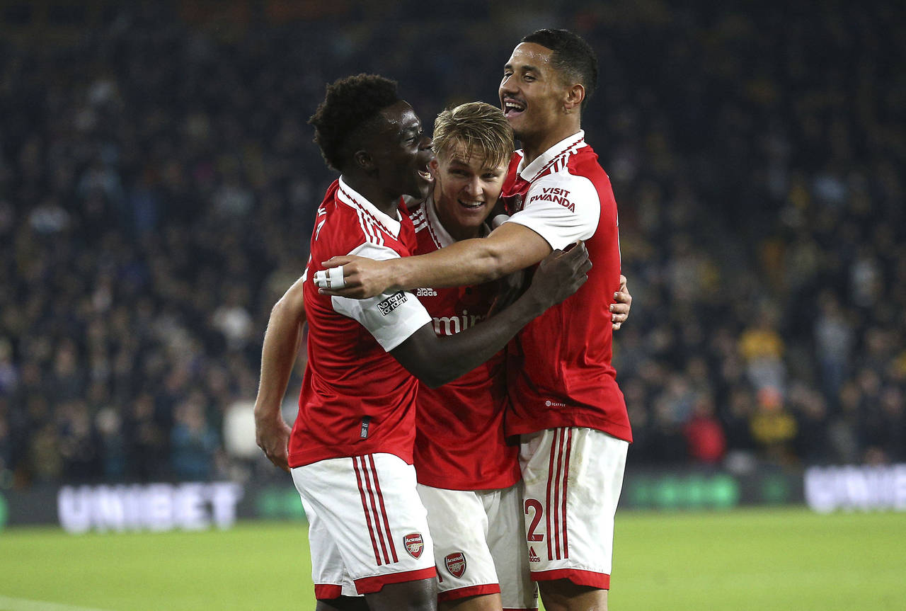 Arsenal's Martin Odegaard, center, celebrates scoring against Arsenal with teammates during the Eng...