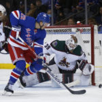 
              Arizona Coyotes goalie Connor Ingram makes the save as Coyotes defenseman Troy Stecher (51) and New York Rangers left wing Jimmy Vesey (26) battle for position in front of the net during the first period of an NHL hockey game, Sunday, Nov. 13, 2022, in New York. (AP Photo/John Munson)
            