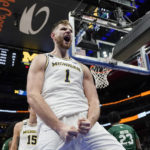 
              Michigan center Hunter Dickinson (1) reacts after a dunk during the second half of an NCAA college basketball game against Eastern Michigan, Friday, Nov. 11, 2022, in Detroit. (AP Photo/Carlos Osorio)
            