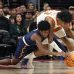 
              Northern Arizona guard Oakland Fort (4) and Texas forward Dillon Mitchell (23) scramble for a loose ball during the first half of an NCAA college basketball game, Monday, Nov. 21, 2022, in Edinburg, Texas. (AP Photo/Eric Gay)
            