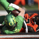 
              Oregon wide receiver Chase Cota, left, and Oregon State defensive back Rejzohn Wright, right, land in the end zone as Cota scores a touchdown during the first half of an NCAA college football game on Saturday, Nov 26, 2022, in Corvallis, Ore. (AP Photo/Amanda Loman)
            