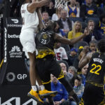 
              Cleveland Cavaliers forward Evan Mobley, top, dunks against Golden State Warriors forward Draymond Green (23) during the second half of an NBA basketball game in San Francisco, Friday, Nov. 11, 2022. (AP Photo/Jeff Chiu)
            