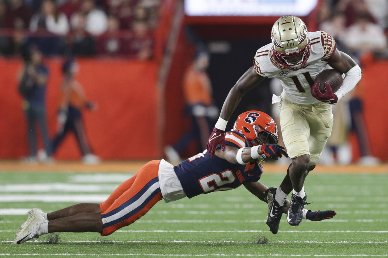 Florida State wide receiver Malik McClain (11) avoids a tackle by Syracuse defensive back Jeremiah ...