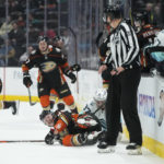 
              Anaheim Ducks' Max Jones (49) falls to the ice after he was checked by Seattle Kraken's Yanni Gourde (37) during the first period of an NHL hockey game Sunday, Nov. 27, 2022, in Anaheim, Calif. (AP Photo/Jae C. Hong)
            