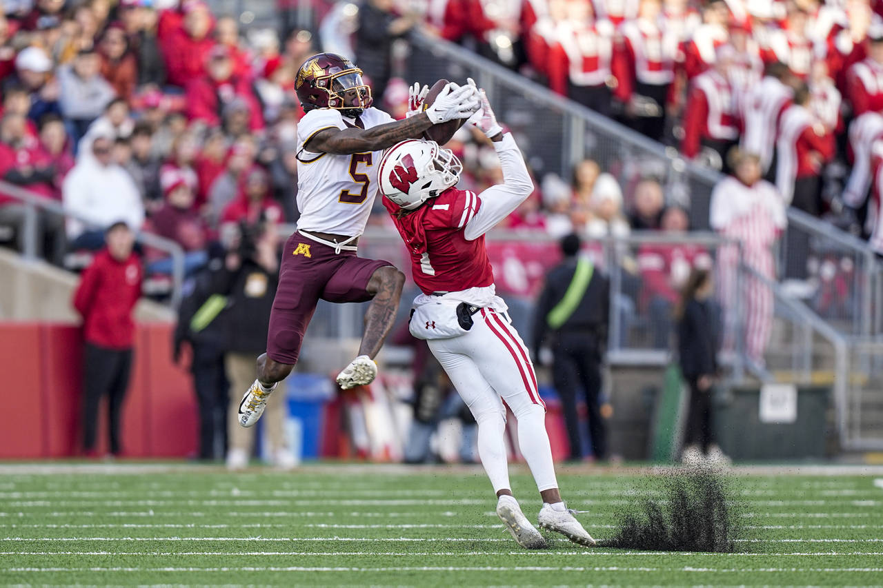 Minnesota wide receiver Dylan Wright (5) makes a reception over Wisconsin cornerback Jay Shaw (1) d...