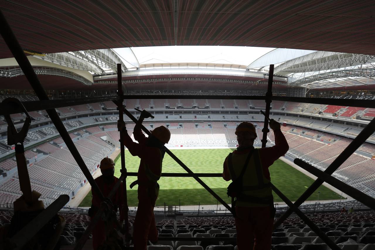 FILE - Laborers remove scaffolding at the Al Bayt stadium in Al Khor, Qatar, about 50 kilometers (3...
