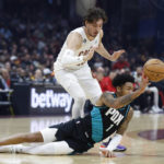 
              Portland Trail Blazers guard Anfernee Simons (1) passes as Cleveland Cavaliers forward Cedi Osman (16) closes in during the first half of an NBA basketball game, Wednesday, Nov. 23, 2022, in Cleveland. (AP Photo/Ron Schwane)
            
