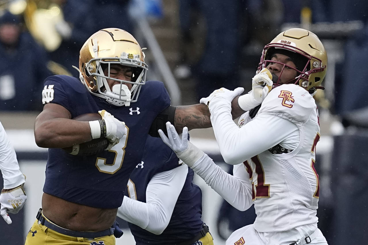 Notre Dame running back Logan Diggs is chased by Boston College defensive back Josh DeBerry during ...