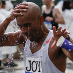 
              A runner throws water on himself as people take part during the New York City Marathon in the Queens borough of New York, Sunday, Nov. 6, 2022. (AP Photo/Eduardo Munoz Alvarez)
            