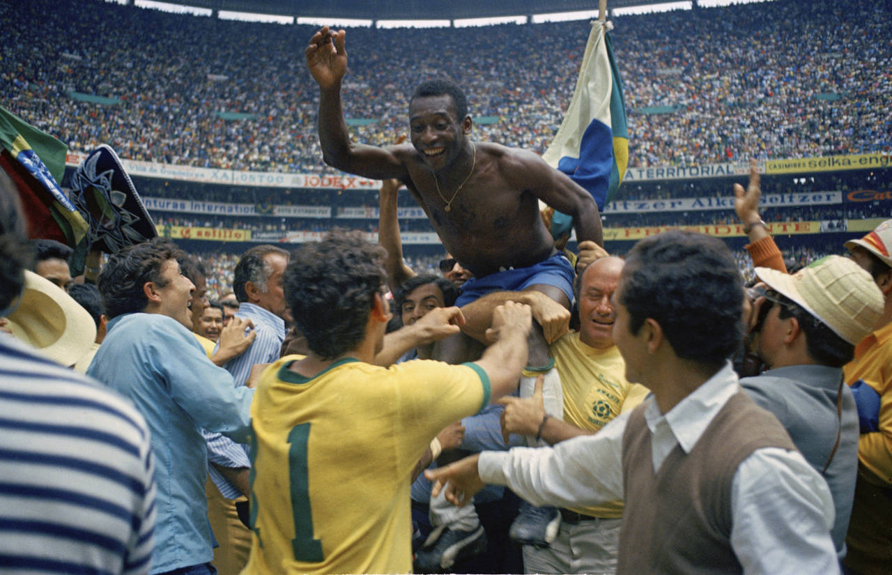 FILE - Brazil's Pele, center, is hoisted on the shoulders of his teammates after Brazil won the Wor...