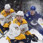 
              Vancouver Canucks' Tyler Myers (57) and Nashville Predators' Michael McCarron (47) vie for the puck behind Mark Jankowski (17) during the first period of an NHL hockey game in Vancouver, British Columbia, on Saturday, Nov. 5, 2022. (Darryl Dyck/The Canadian Press via AP)
            