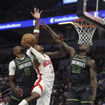 
              Houston Rockets guard Kevin Porter Jr. (3) tries to shoot from between Minnesota Timberwolves forward Taurean Prince (12) and center Naz Reid (11) during the second half of an NBA basketball game Saturday, Nov. 5, 2022, in Minneapolis. The Timberwolves won 129-117. (AP Photo/Stacy Bengs)
            