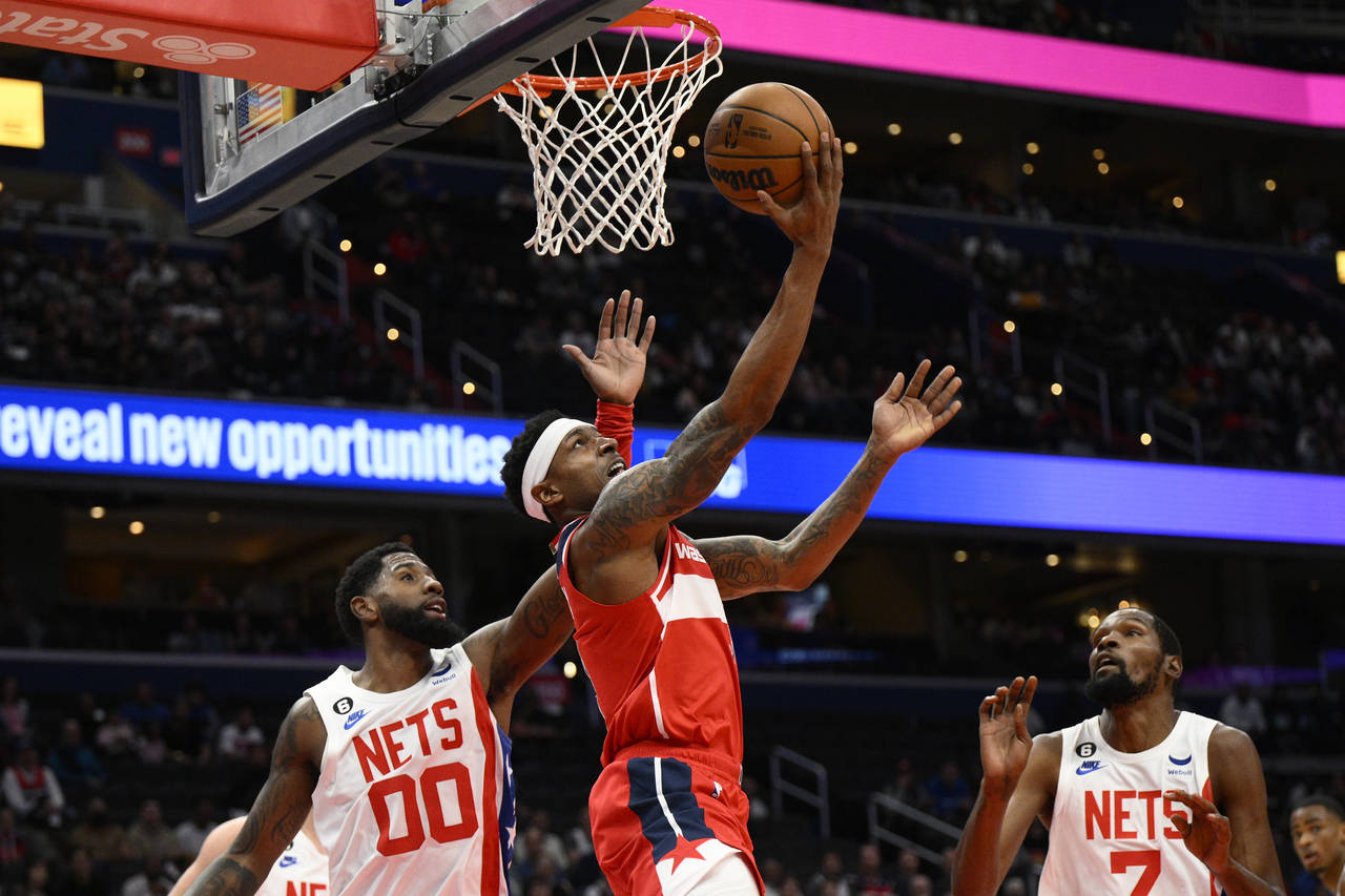 Washington Wizards guard Bradley Beal goes to the basket between Brooklyn Nets forward Royce O'Neal...