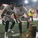 
              Purdue's Zac Tuinei (52) and Nick Zecchino (31) grab the Old Oaken Bucket after defeating Indiana in an NCAA college football game, Saturday, Nov. 26, 2022, in Bloomington, Ind. (AP Photo/Darron Cummings)
            