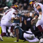
              Washington Commanders quarterback Taylor Heinicke (4) is tripped by Philadelphia Eagles defensive tackle Javon Hargrave during the second half of an NFL football game, Monday, Nov. 14, 2022, in Philadelphia. (AP Photo/Matt Rourke)
            