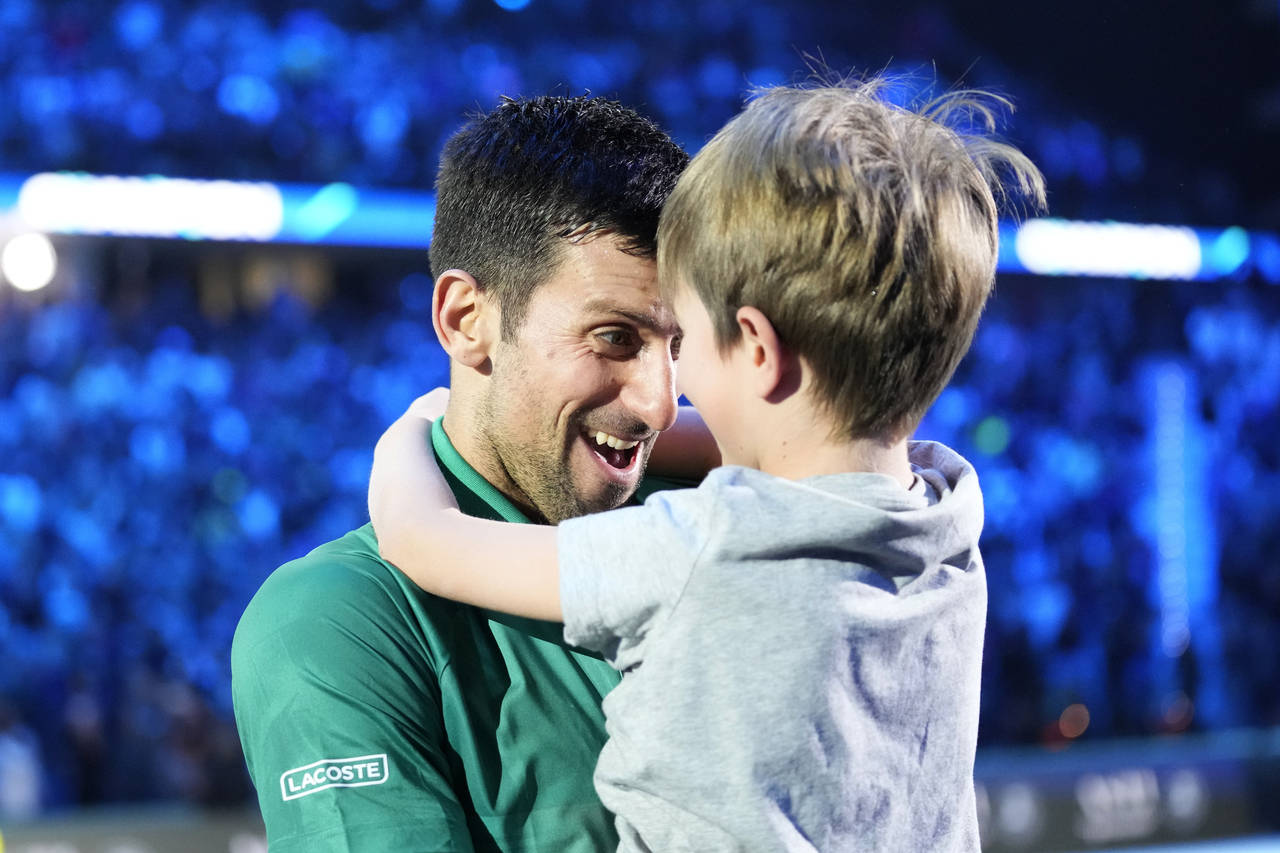 Serbia's Novak Djokovic celebrates with his son after defeating Norway's Casper Ruud 7-5, 6-3, in t...