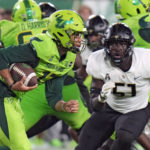 
              South Florida quarterback Byrum Brown (17) runs past UCF defensive end Malachi Lawrence (51) during the first half of an NCAA college football game Saturday, Nov. 26, 2022, in Tampa, Fla. (AP Photo/Chris O'Meara)
            