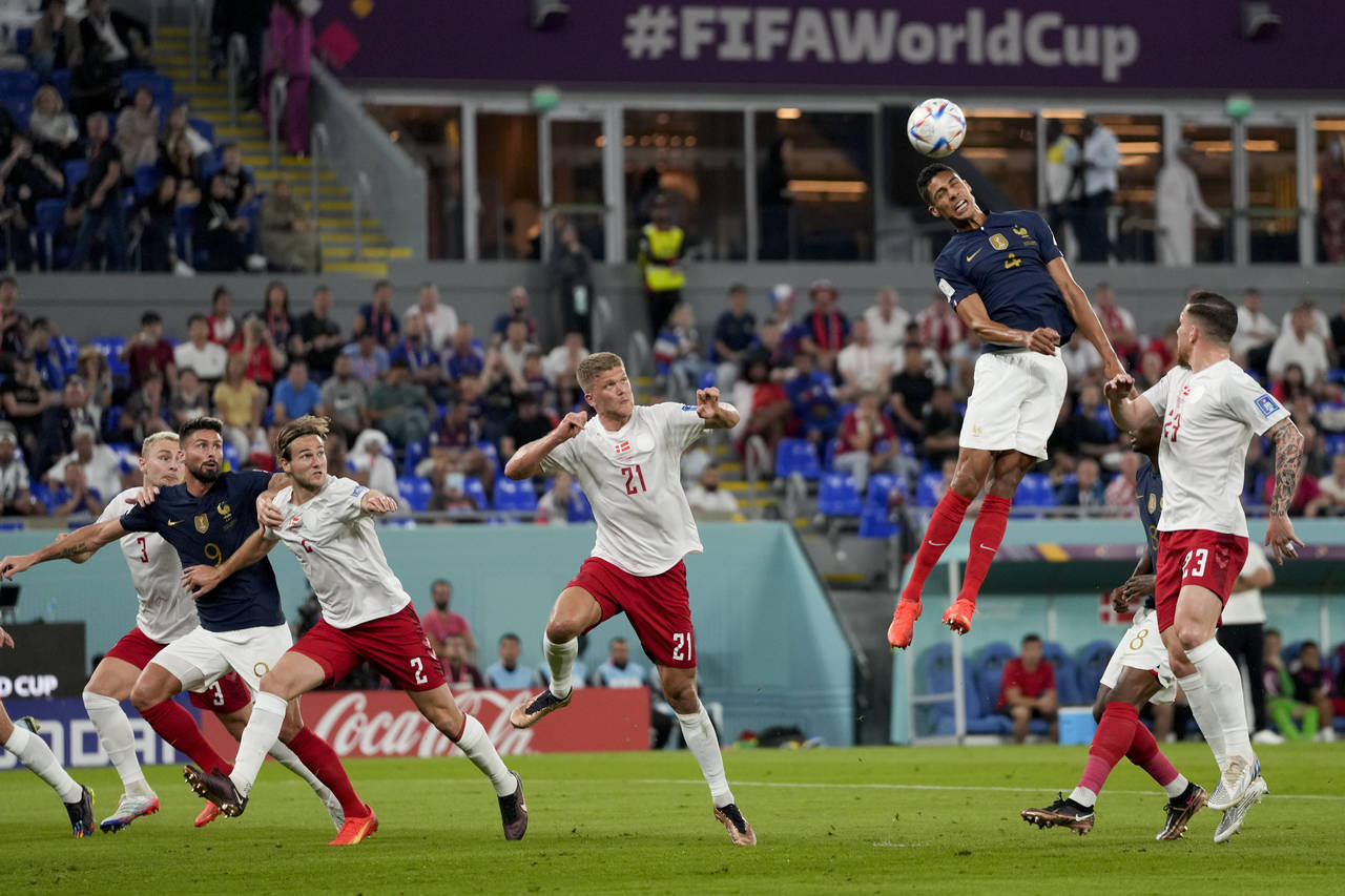 France's Raphael Varane, second right, goes for a header during the World Cup group D soccer match ...