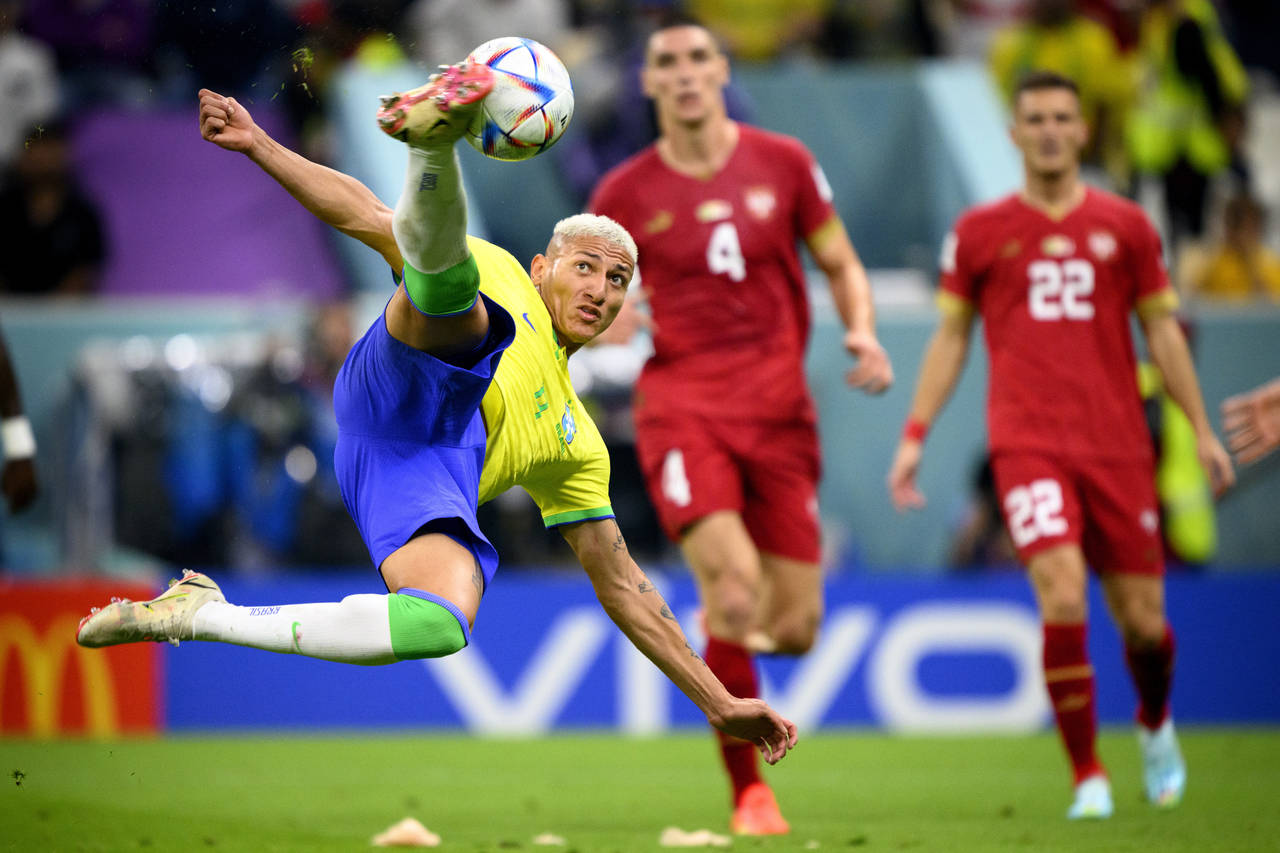 Brazil's forward Richarlison, left, scores the second goal for his team during the World Cup group ...