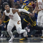 
              Cleveland Cavaliers guard Donovan Mitchell, left, brings the ball up the court in front of Golden State Warriors forward Jonathan Kuminga (00) during the first half of an NBA basketball game in San Francisco, Friday, Nov. 11, 2022. (AP Photo/Jeff Chiu)
            