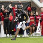 
              Cincinnati wide receiver Tyler Scott (21) scores during the first half of an NCAA college football game against Navy, Saturday, Nov. 5, 2022, in Cincinnati. (AP Photo/Jeff Dean)
            