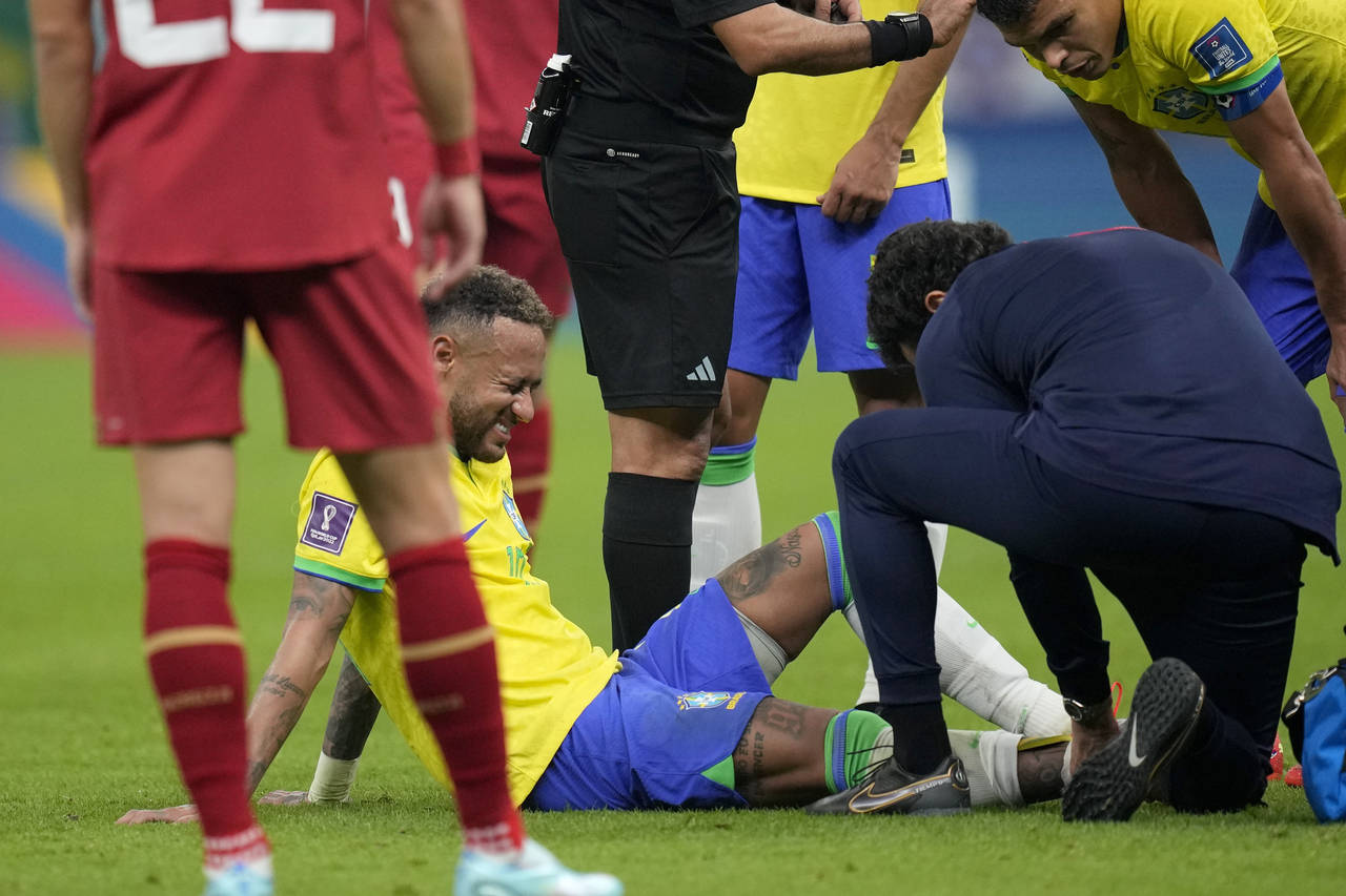 El delantero brasileño Neymar recibe tratamiento durante el partido contra Serbia por el Grupo G d...