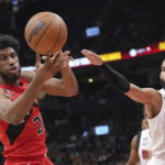
              Toronto Raptors' Thaddeus Young, left, tries to gather in the ball, next to Miami Heat's Caleb Martin during the first half of an NBA basketball game Wednesday, Nov. 16, 2022, in Toronto. (Chris Young/The Canadian Press via AP)
            