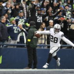 
              Las Vegas Raiders running back Josh Jacobs (28) celebrates after scoring a touchdown during the first half of an NFL football game against the Seattle Seahawks Sunday, Nov. 27, 2022, in Seattle. (AP Photo/Caean Couto)
            