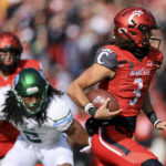 
              Cincinnati quarterback Evan Prater (3) carries the ball during the first half of an NCAA college football game against Tulane, Friday, Nov. 25, 2022, in Cincinnati. (AP Photo/Aaron Doster)
            