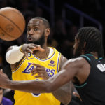 
              Los Angeles Lakers forward LeBron James, left, passes the ball as Portland Trail Blazers forward Justise Winslow defends during the first half of an NBA basketball game Wednesday, Nov. 30, 2022, in Los Angeles. (AP Photo/Mark J. Terrill)
            