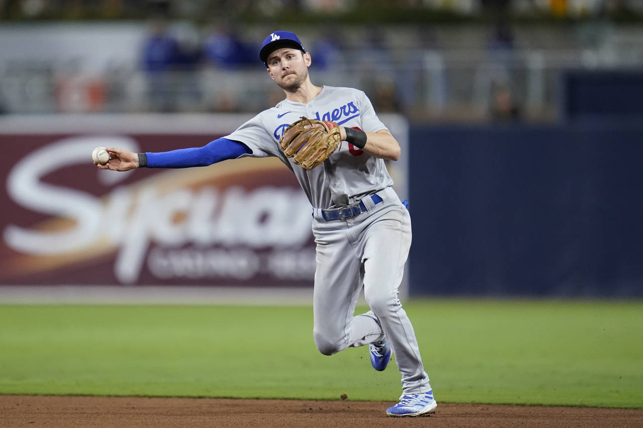 Los Angeles Dodgers shortstop Trea Turner throws to first for the out on San Diego Padres' Jake Cro...
