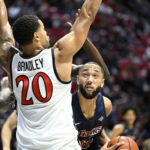 
              Cal State Fullerton forward Vincent Lee (13) tries to shoot past San Diego State guard Matt Bradley (20) during the first half of an NCAA college basketball game Monday, Nov. 7, 2022, in San Diego. (AP Photo/Denis Poroy)
            