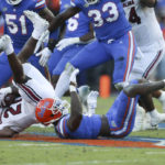 
              Florida safety Trey Dean III, bottom right, tackles South Carolina running back Juju McDowell (21) for a loss during the first half of an NCAA college football game Saturday, Nov. 12, 2022, in Gainesville, Fla. (AP Photo/Matt Stamey)
            