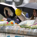
              Mourners place flowers on a bridge near the scene of a shooting on the grounds of the University of Virginia Tuesday Nov. 15, 2022, in Charlottesville. Va. Authorities say three people have been killed and two others were wounded in a shooting at the University of Virginia and a student suspect is in custody. (AP Photo/Steve Helber)
            