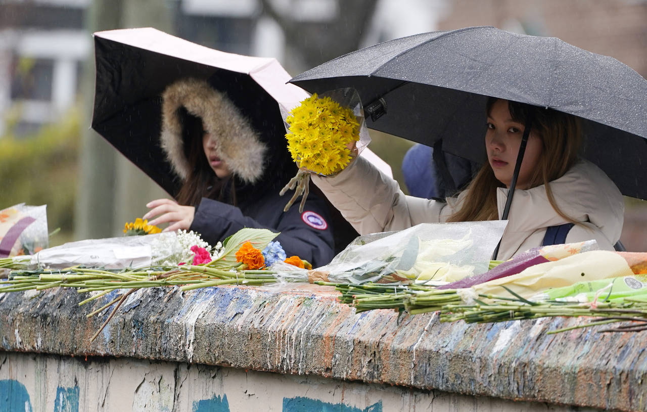 Mourners place flowers on a bridge near the scene of a shooting on the grounds of the University of...