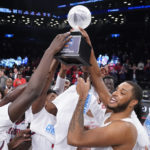 
              St. John's Joel Soriano, center right, raises the championship trophy as he celebrates with his teammates after winning an NCAA college basketball championship game against Syracuse at the Good Samaritan Empire Classic, Tuesday, Nov. 22, 2022, in New York. (AP Photo/John Minchillo)
            