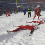 
              FILE - Buffalo Bills players make snow angels in the snow after defeating the Indianapolis Colts after an NFL football game, on Sunday, Dec. 10, 2017, in Orchard Park, N.Y. The NFL is monitoring the weather and has contingency plans in place in the event a lake-effect snowstorm hitting the Buffalo disrupts the Bills ability to host the Cleveland Browns on Sunday, Nov. 20, 2022. (AP Photo/Adrian Kraus, File)
            