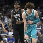 
              Charlotte Hornets guard LaMelo Ball, right, reacts after scoring a 3-point basket in front of Orlando Magic center Wendell Carter Jr. (34) during the second half of an NBA basketball game, Monday, Nov. 14, 2022, in Orlando, Fla. (AP Photo/Phelan M. Ebenhack)
            