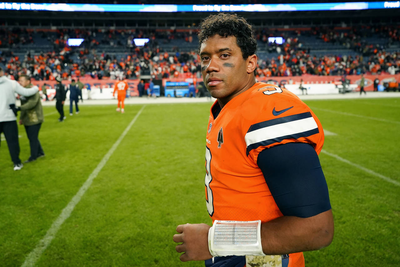 Denver Broncos quarterback Russell Wilson walks off the field after an NFL football game against th...