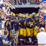 
              FILE - Michigan head coach Jim Harbaugh leads his players out of the Michigan Stadium tunnel to take the field before an NCAA college football game against BYU in Ann Arbor, Mich., Saturday, Sept. 26, 2015. Michigan Stadium is one of the few places left in American sports where the home and visiting teams use the same tunnel to enter and exit the field, a design popular in venues built in the early 20th century but rare now. (AP Photo/Tony Ding, File)
            