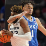 
              Duke center Dereck Lively II (1) fouls Xavier forward Dieonte Miles (22) during the second half of an NCAA college basketball game in the Phil Knight Legacy tournament Friday, Nov. 25, 2022, in Portland, Ore. (AP Photo/Rick Bowmer)
            